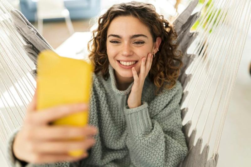 Pretty woman making video call with smartphone, at home