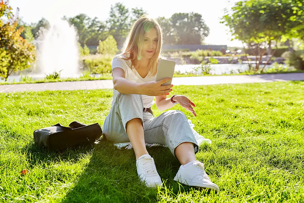 Young woman talking on the phone during a video chat on Omegle, smiling and making eye contact with the screen.