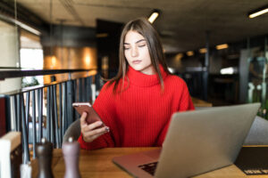 Young woman using a laptop and phone while exploring Umigle online